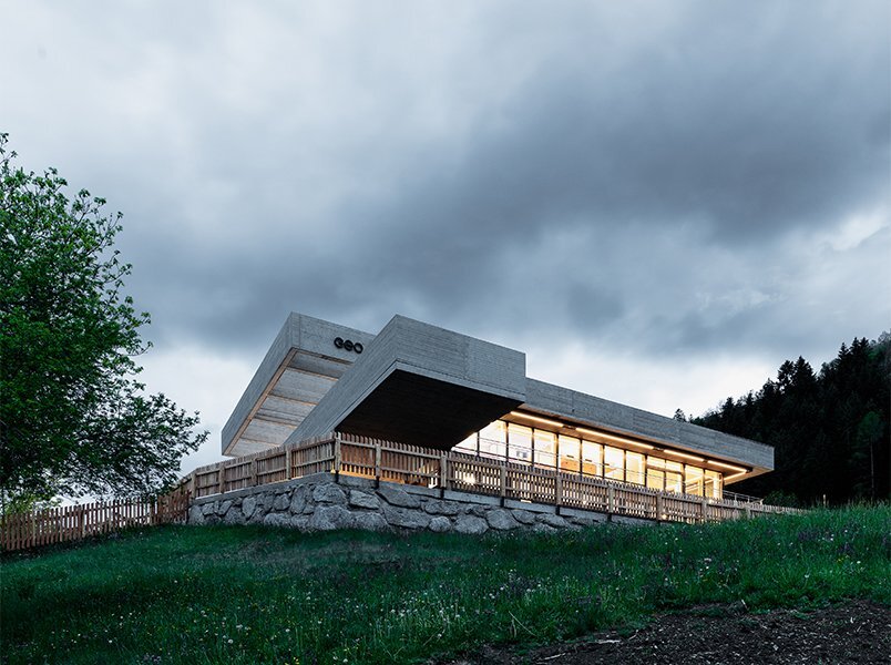 alleswirdgut's new community center in austria hovers over land as two suspended planes