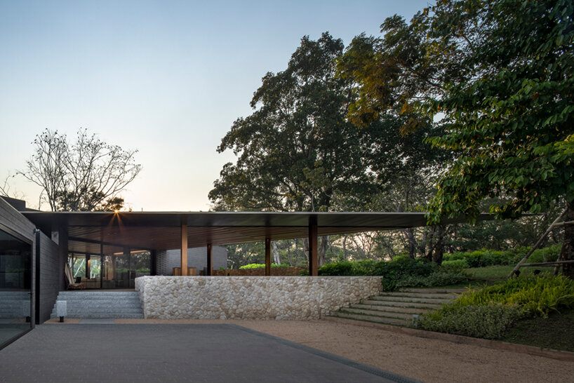 thailand-based architects 49 integrates its diagonal house into the forested landscape