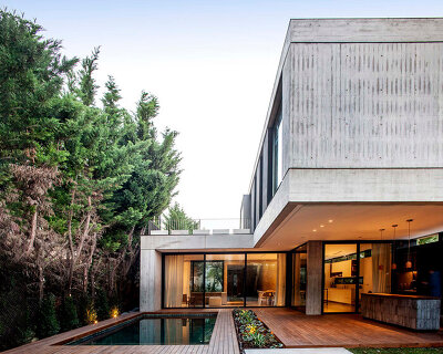 this house in buenos aires is a concrete box that floats above a garden lagoon