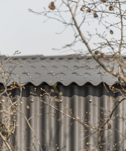 KONKRET studio wraps hungarian family house in dark corrugated slates