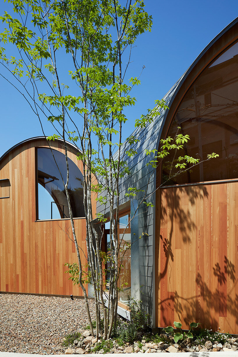 a series of tilted vaulted roofs tops wooden house by tomohiro hata in koyoen, japan