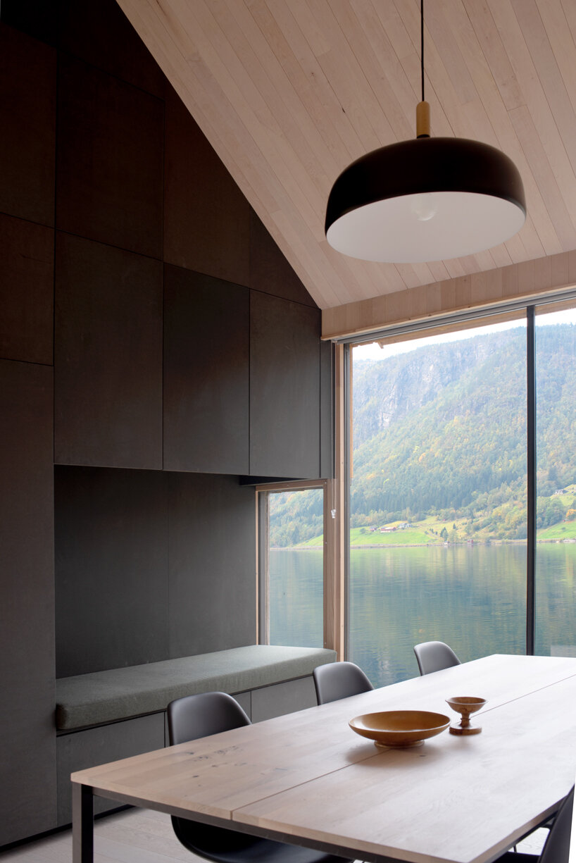 a slanted beam supports this fjord-side cabin in western norway