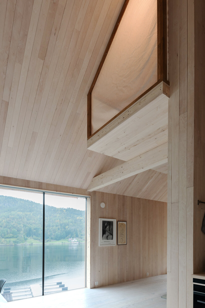 a slanted beam supports this fjord-side cabin in western norway