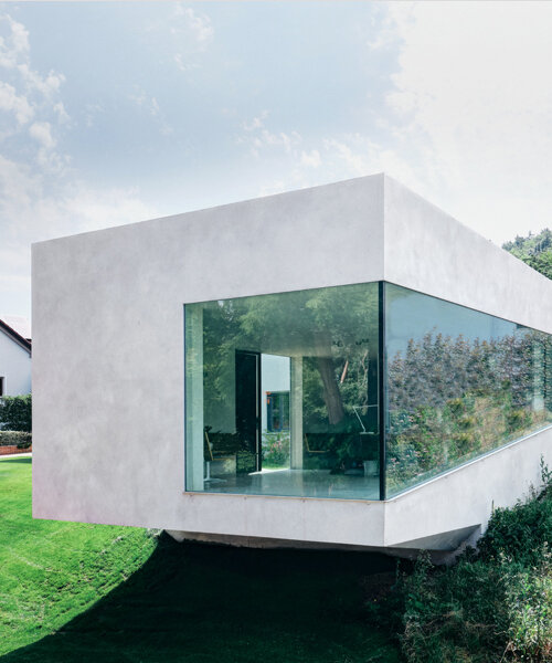 this german medical clinic sits as a protruding, off-white volume with dramatic glazing