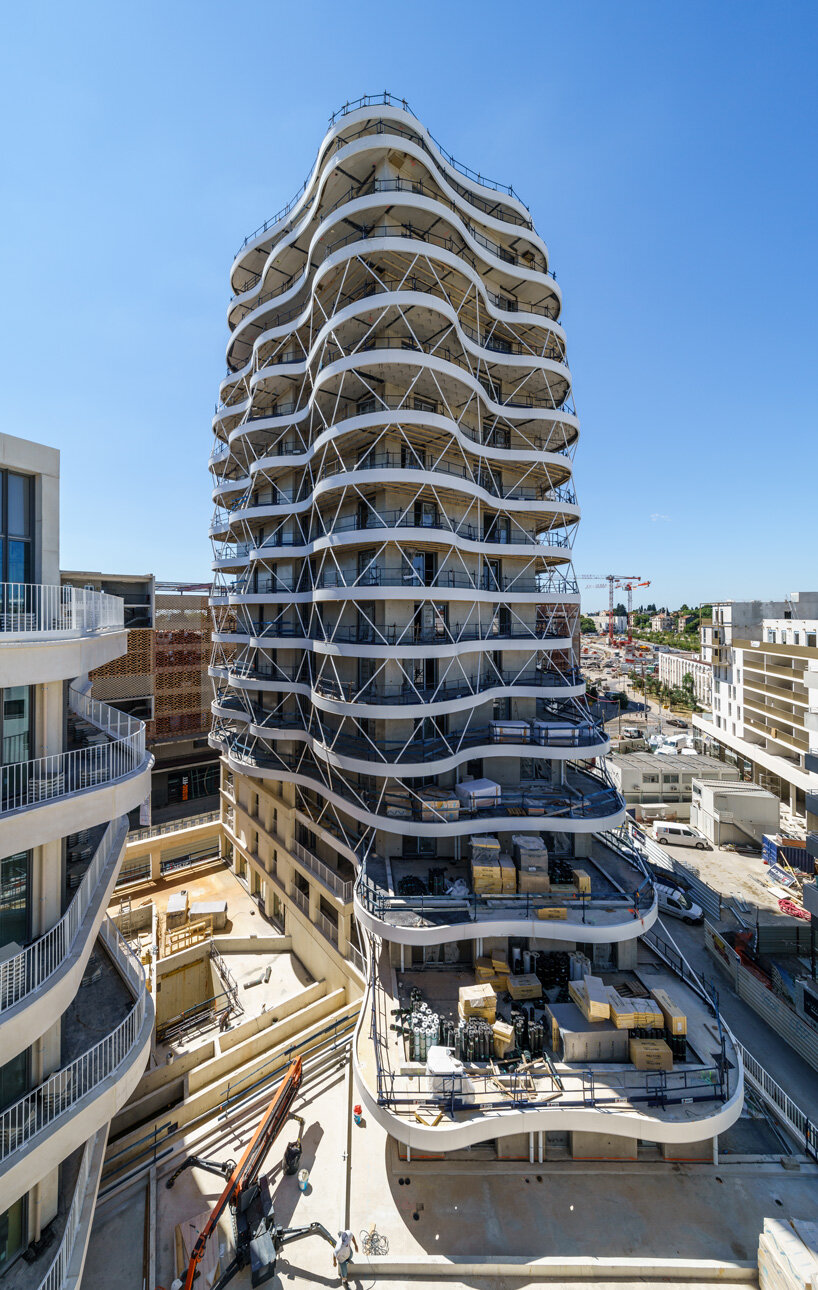 a housing tower with stacked and staggered undulating terraces takes shape in montpellier