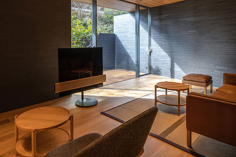 kawazoe architects binds three buildings into a home with a curved path in japan