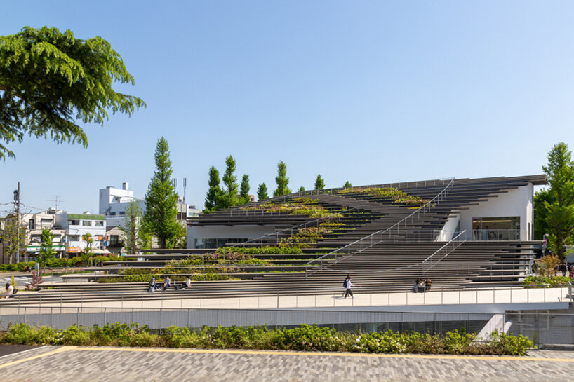 kengo kuma encloses this underground student center with a fluid green roof