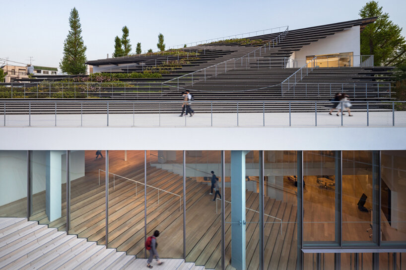 kengo kuma encloses this underground student center with a fluid green roof