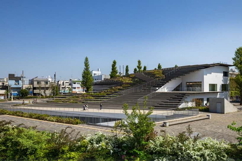 kengo kuma encloses this underground student center with a fluid green roof