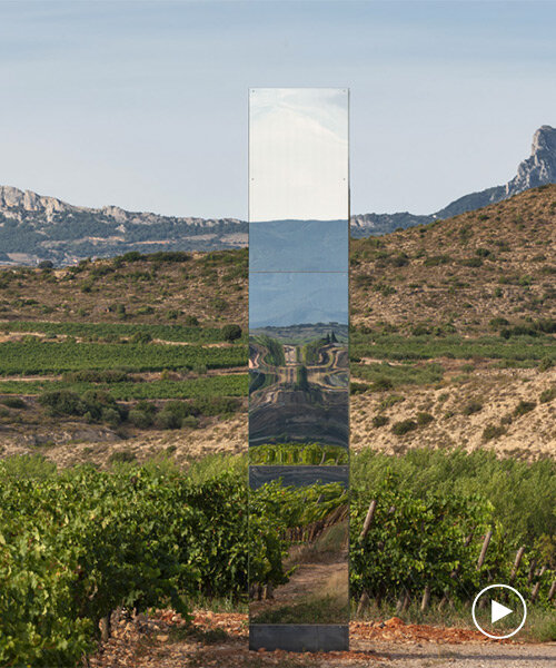 mirror-clad tower emerges as an ephemeral landmark within spanish vineyard