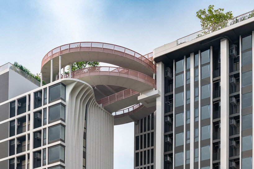 openbox architects inserts rose gold spiral ramp between two residential towers in bangkok