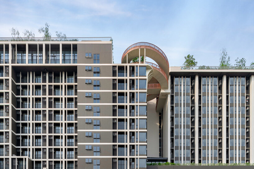 openbox architects inserts rose gold spiral ramp between two residential towers in bangkok