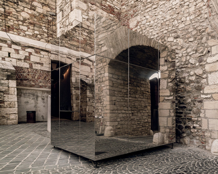 these reflective kiosks in budapest seamlessly blend into their historic surroundings