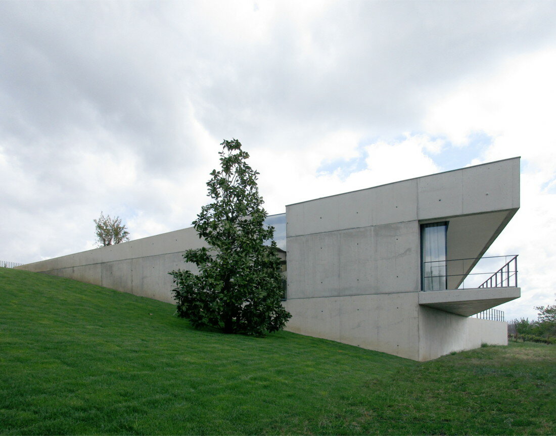 UTOPIA's concrete house gently digs into its greenery terrain in portugal