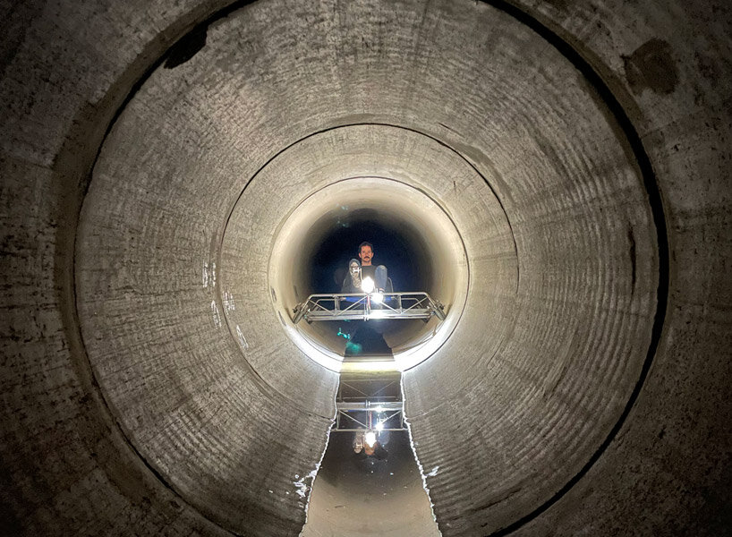 a bike inside a tunnel: artist fernando abellanas pedals through a sewer with ‘enlace’
