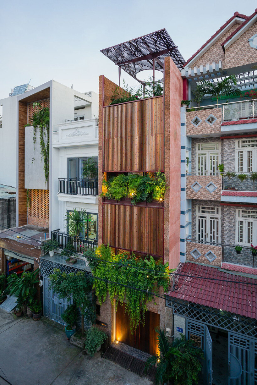 wooden revolving shutters clad the facade of AD9 architects' H house in vietnam