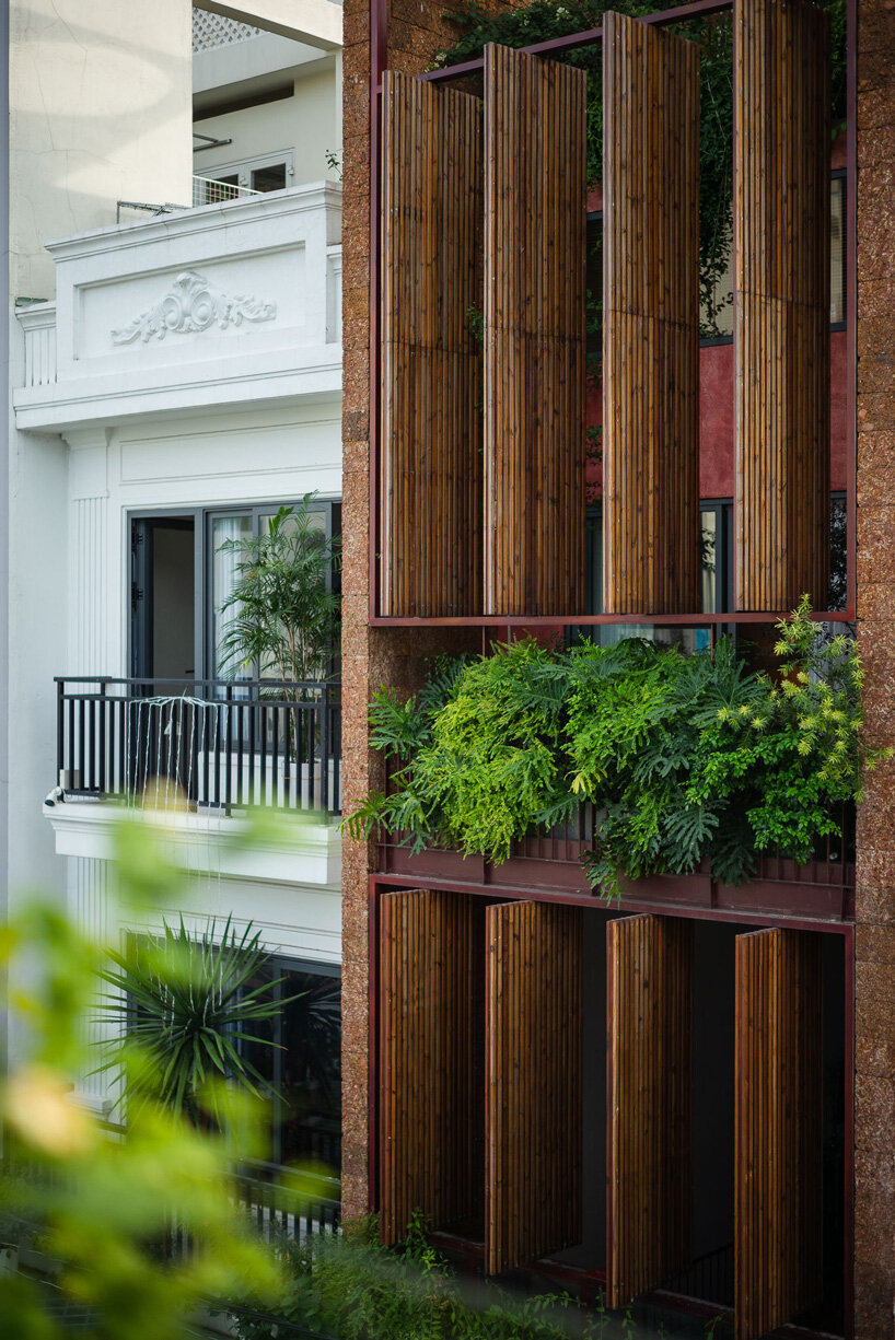 revolving wooden shutters clad the facade of AD9 architects' H house in vietnam