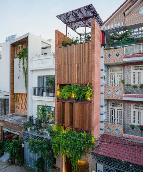 revolving wooden shutters clad the facade of AD9 architects' H house in vietnam