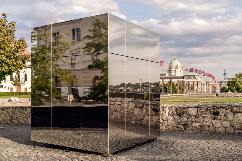 these reflective kiosks in budapest seamlessly blend into their historic surroundings