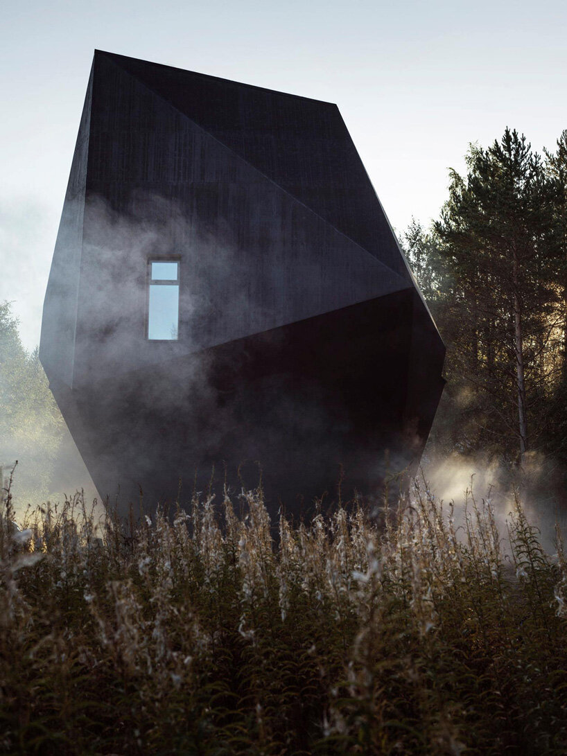 ateljé sotamaa's 'meteorite' residence in finland emerges as a mystical dark object