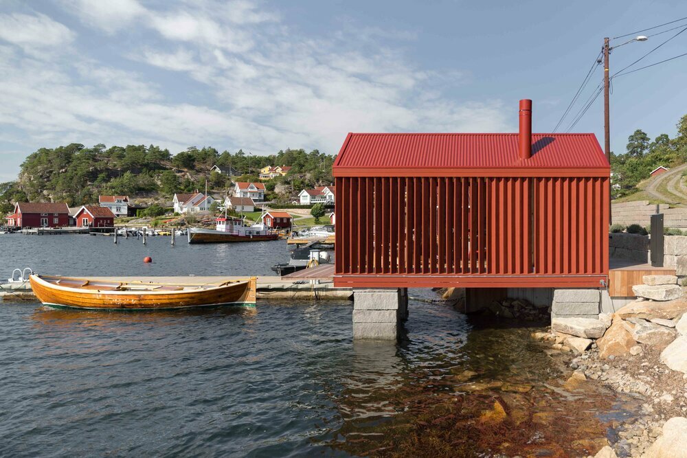red-painted wooden cladding envelops tiny boathouse by handegård arkitektur in norway