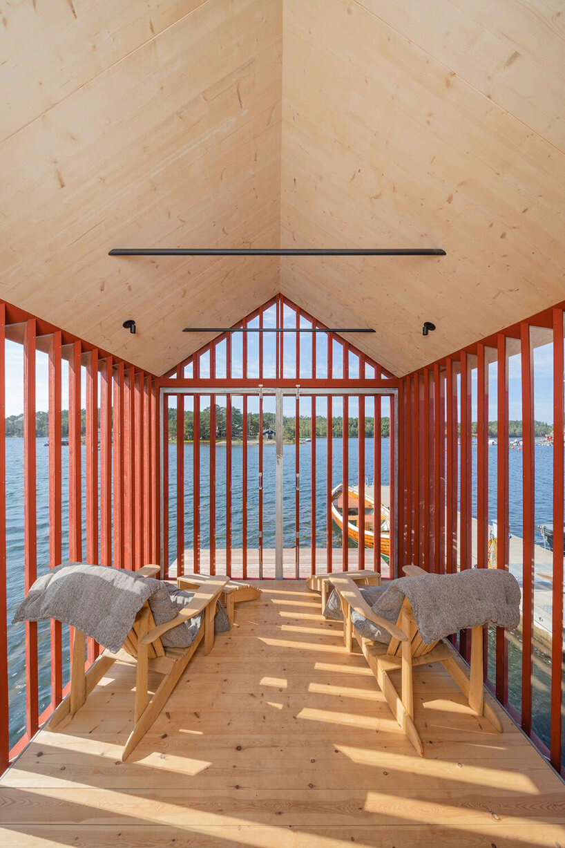 red-painted wooden cladding envelopes tiny boathouse by handegård arkitektur in finland