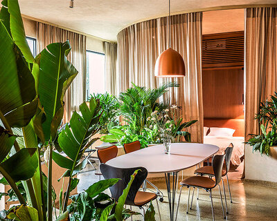 scandinavian furniture peeks through tropical plants in vietnamese residence by studio anettai