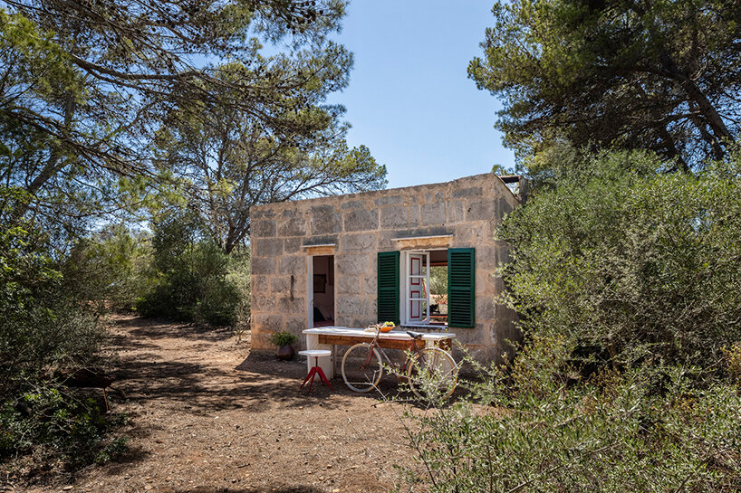 Red window pops out of Mariana de Delás' traditional stone shelter renovation in Mallorca