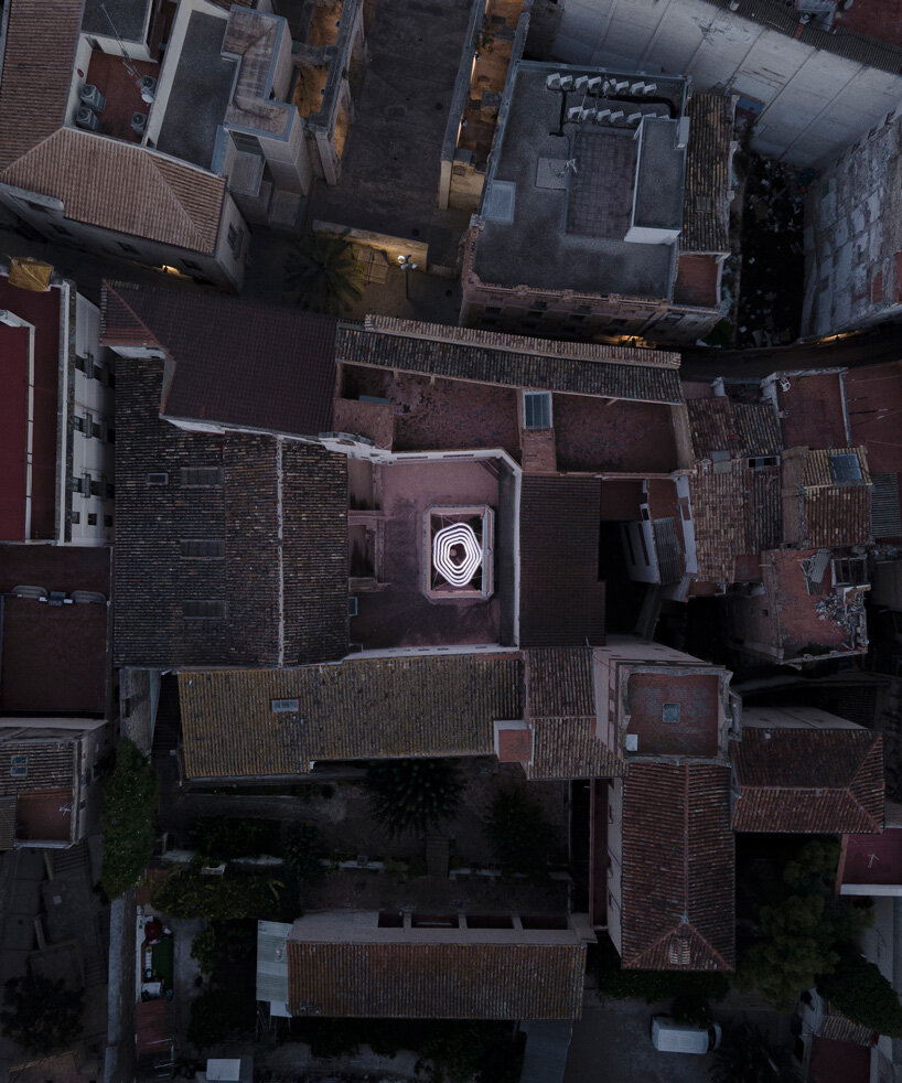 monumental lamp installation lights up the main patio of a 17th century monastery in spain