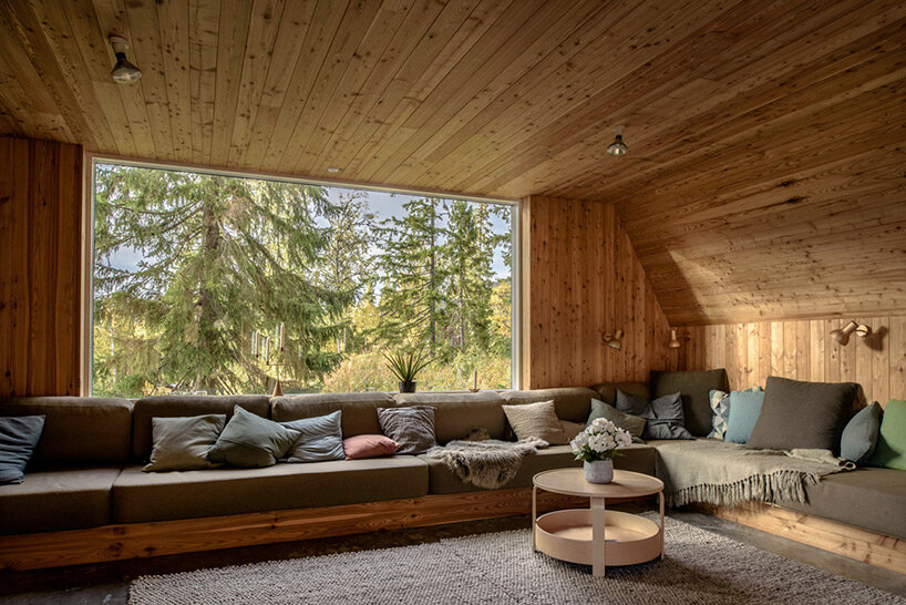 prefab A-frame ski lodge with curved windows opens to the alpine landscape of sweden