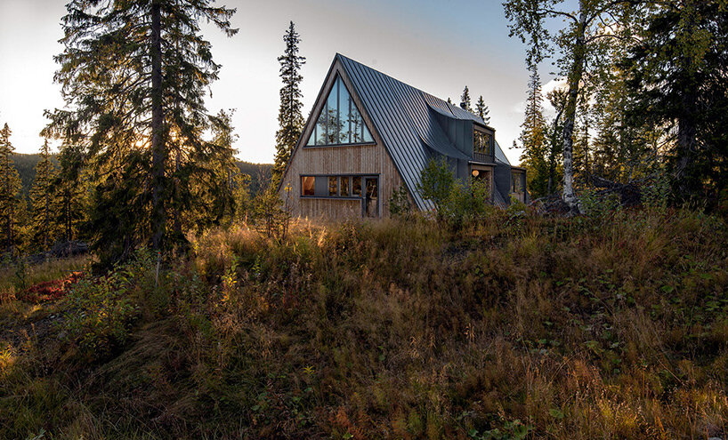 prefab A-frame ski lodge with curved windows opens to the alpine landscape of sweden