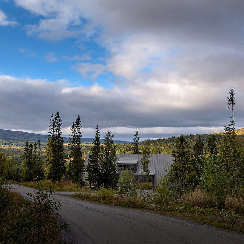 prefab A-frame ski lodge with curved windows opens to the alpine landscape of sweden