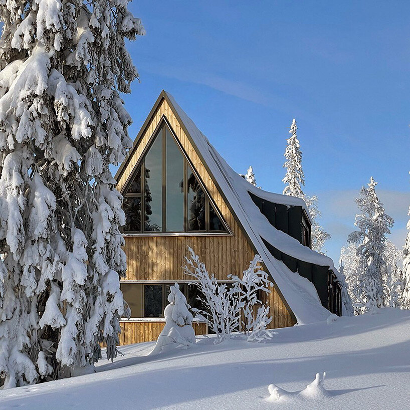 prefab A-frame ski lodge with curved windows opens to the alpine landscape of sweden