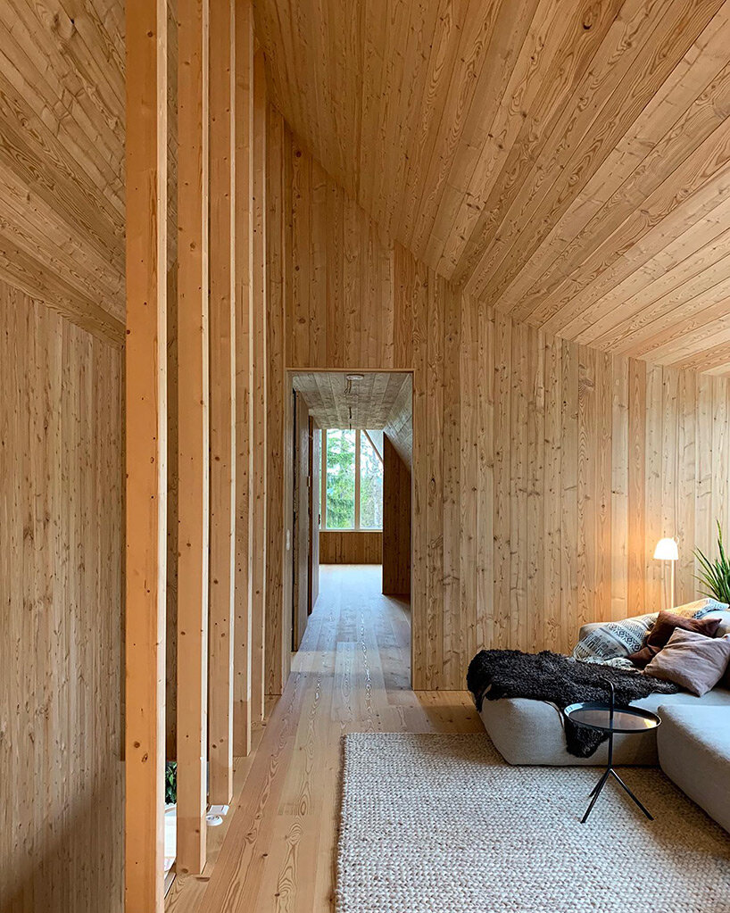 prefab A-frame ski lodge with curved windows opens to the alpine landscape of sweden