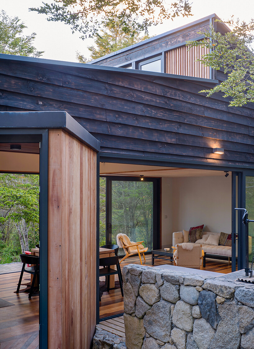 minimalistic cabin by hebra arquitectos emerges from a stone plinth in chile