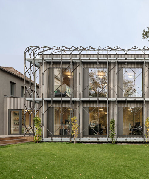 a shell for climbing plants wraps this timber office pavilion in vienna