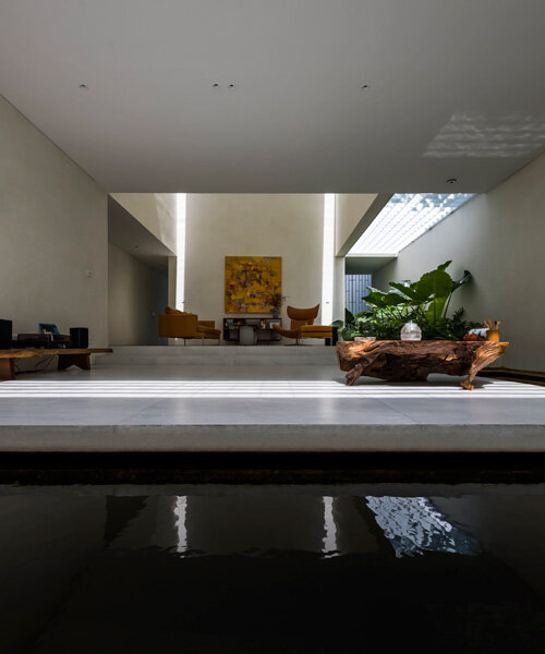 interior fish pond surrounds the living area of 23o5 studio's serene house in vietnam
