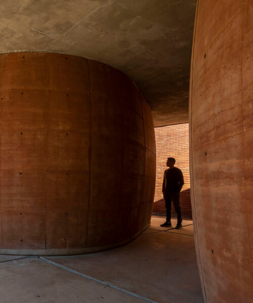 these toilets at paraguay's university of asunción are a cluster of rammed-earth boulders