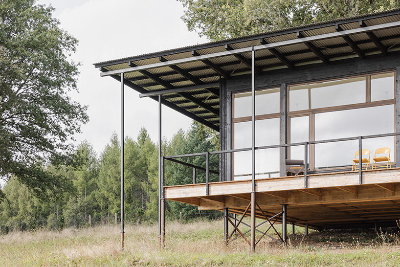 cantilevered wooden house by ciguë floats lightly above verdant field in france