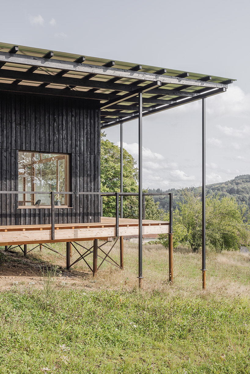 cantilevered wooden house by ciguë floats lightly above verdant field in france