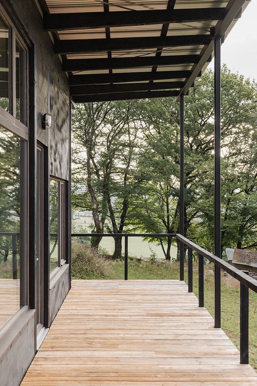 cantilevered wooden house by ciguë floats lightly above verdant field in france