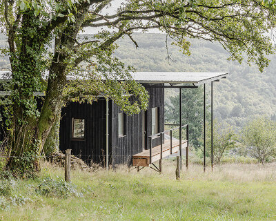 Cantilevered wooden house by Ciguë floats lightly above verdant field in France