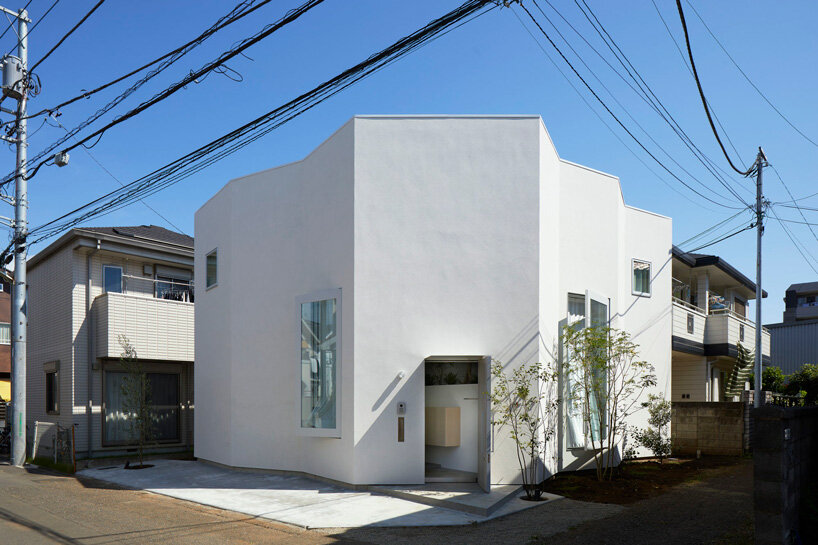 japanese residence by airhouse encloses minimalist interior of slanted floors and walls