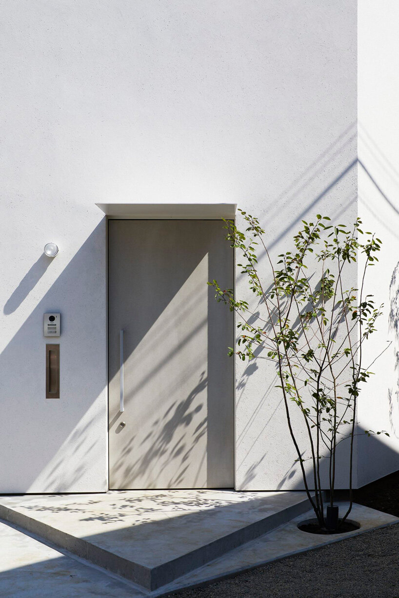 japanese residence by airhouse conceals minimalist interior of slanted floors and walls