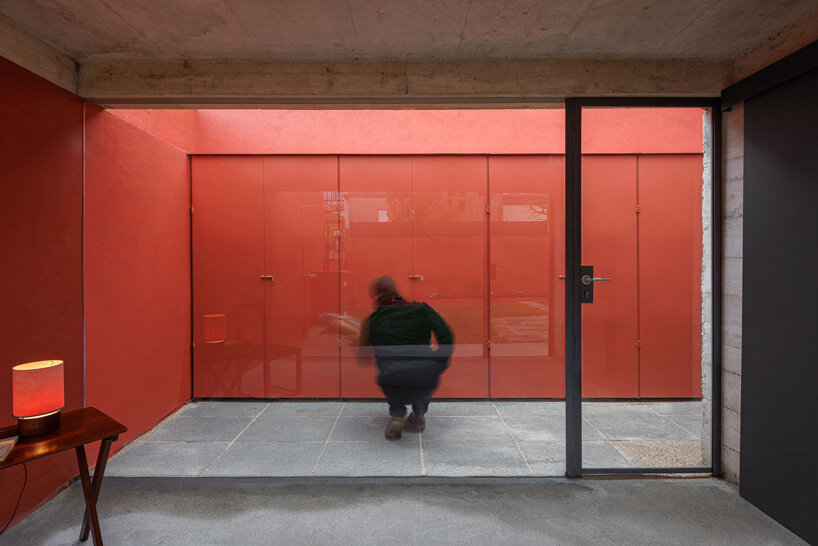 white concrete encloses josé pedro lima's bright red multi-use garden pavilion in portugal
