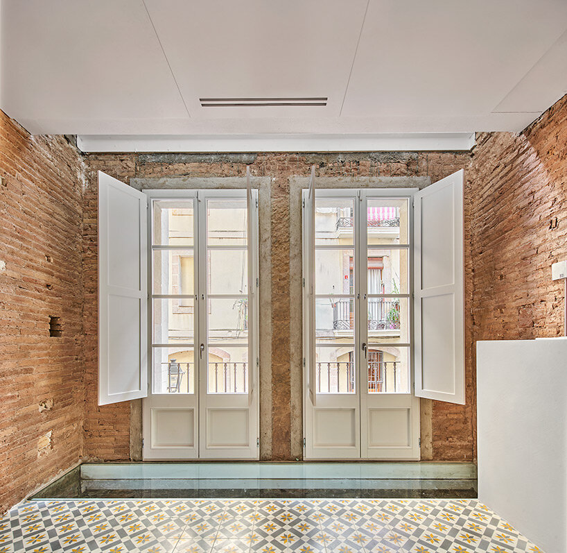 raúl sánchez adorns exposed brick interior with brass kitchen in renovated barcelona house