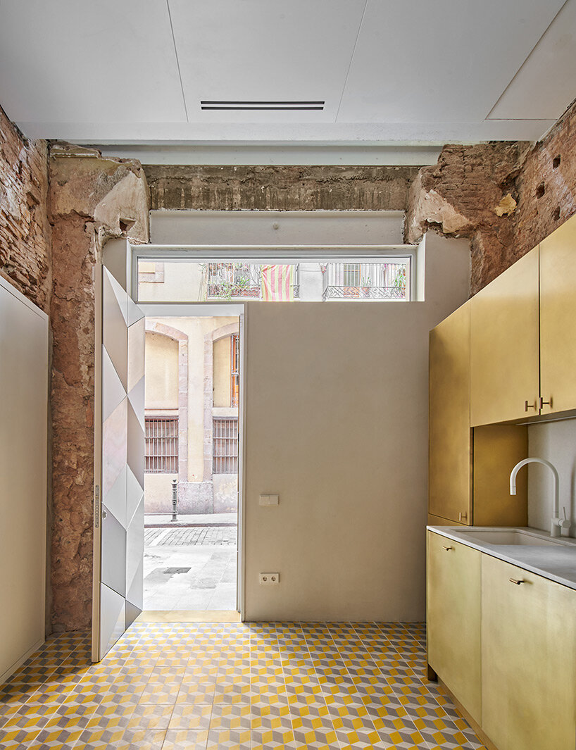 raúl sánchez adorns exposed brick interior with brass kitchen in renovated barcelona home