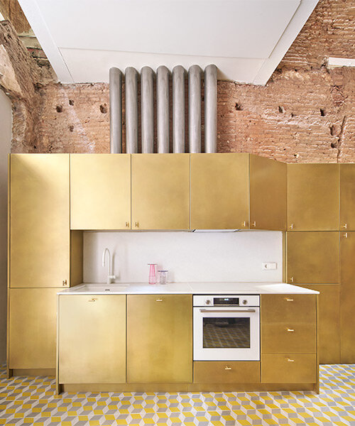 raúl sánchez adorns exposed brick interior with brass kitchen in renovated barcelona house