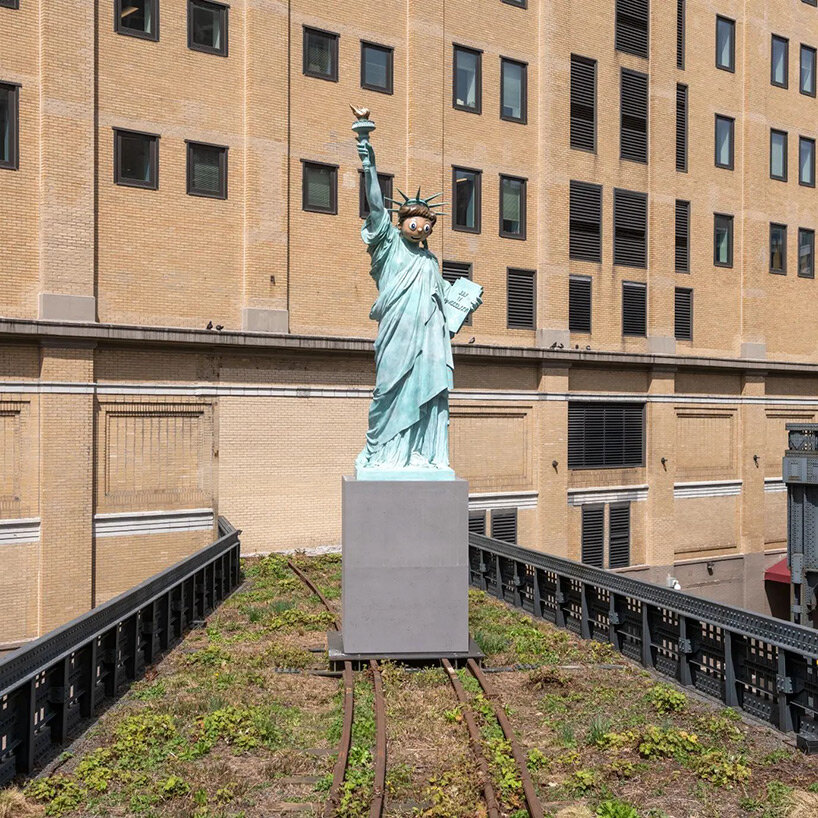 statue of liberty with emoji-inspired mask by paola pivi rises at the high line, NYC