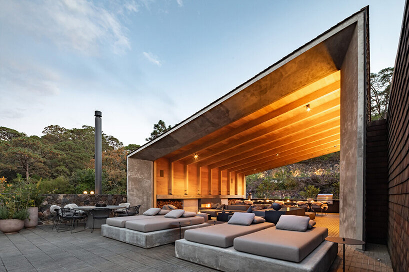 nestled atop steep hills, these twin homes in Mexico blend into their forest backdrop